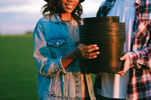 Free People Holding Black Plastic Pot Stock Photo