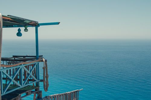 Free Picturesque scenery of terrace of coastal house against endless blue rippling sea on sunny day Stock Photo