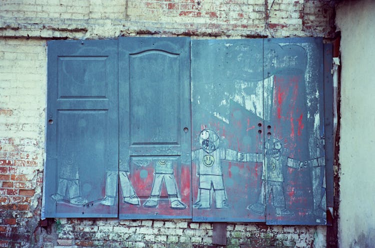 Shabby Wooden Door With Graffiti On Weathered Stone Wall