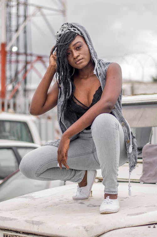 Selective Focus Photo of a Woman with Dreadlocks Crouching