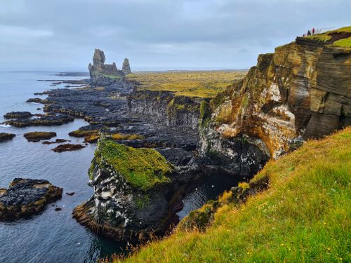 Free From above of various rocky formations and stones covered with grass and moss in sea water near rocky coast on cloudy day Stock Photo