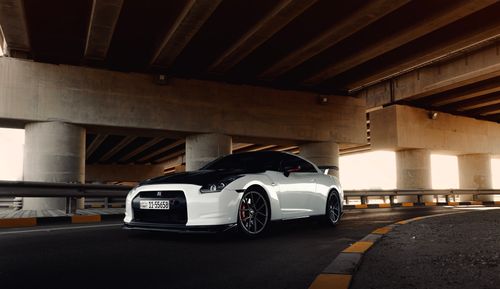 Free Dynamic shot of a high-performance white sports car parked under a bridge. Stock Photo