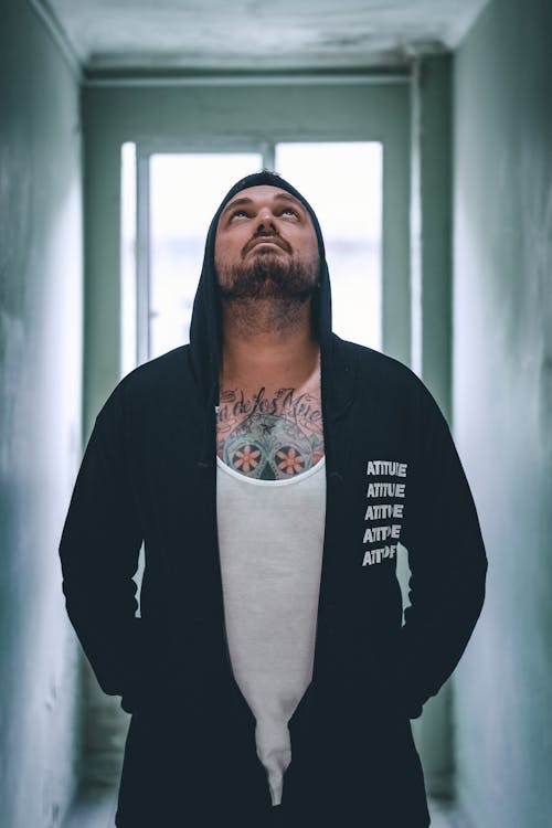Photo of a Man in a Black Hoodie Looking Up