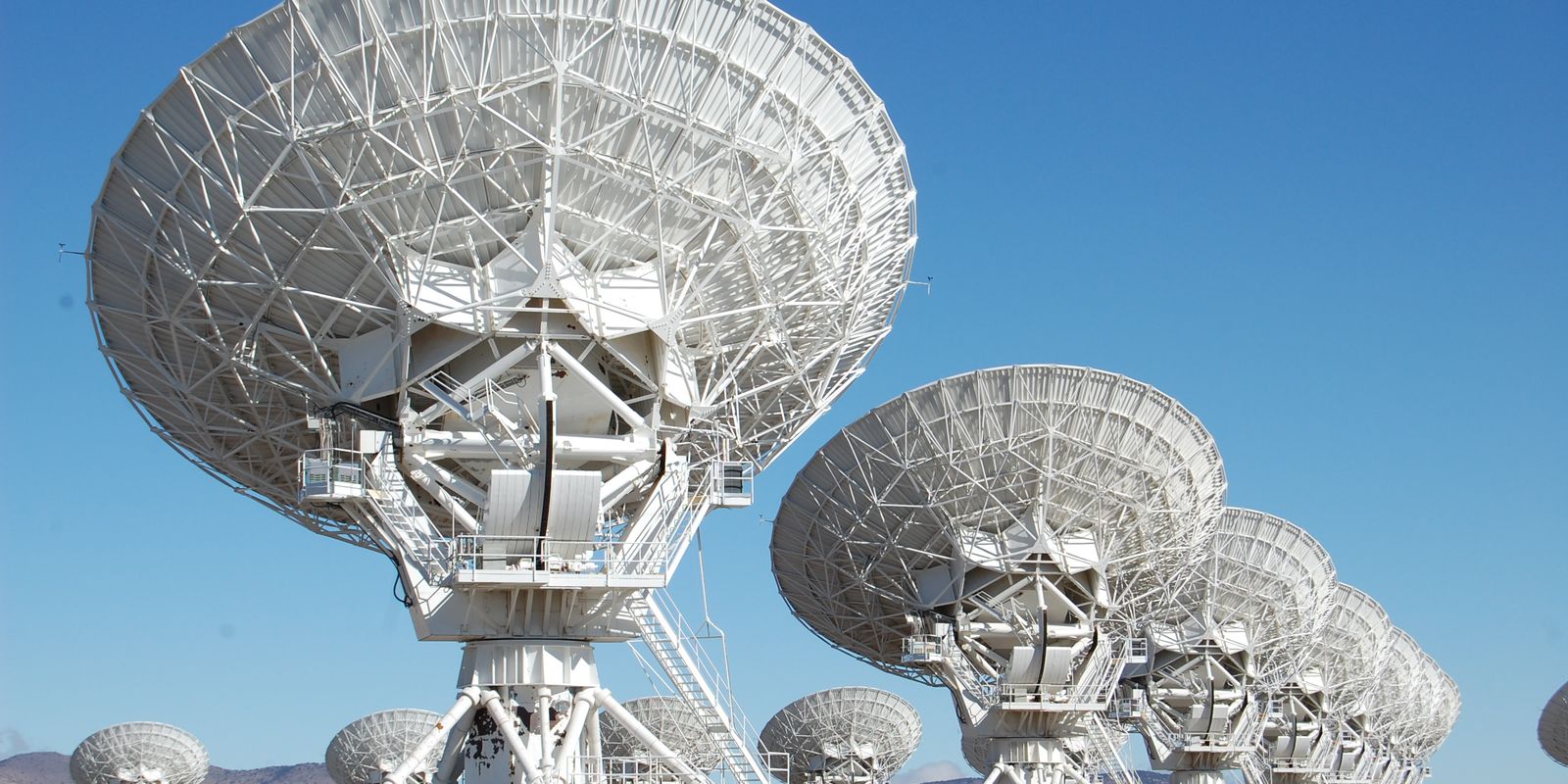 Array of radio telescope dishes under a clear sky