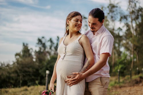 A Man Standing Behind a Pregnant Woman