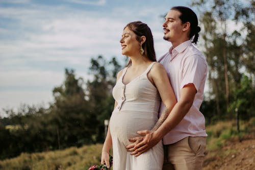 Man and Woman Standing on Green Grass Field