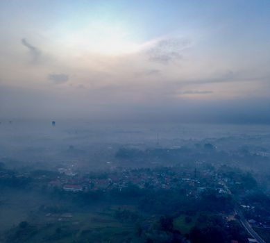 A misty morning view over a landscape in Banten, Indonesia, showcasing fog-covered terrain. - Fotografer Sidoarjo