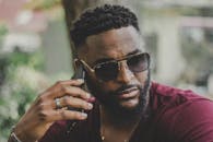 一位时尚男子在阳光明媚的户外打电话的肖像