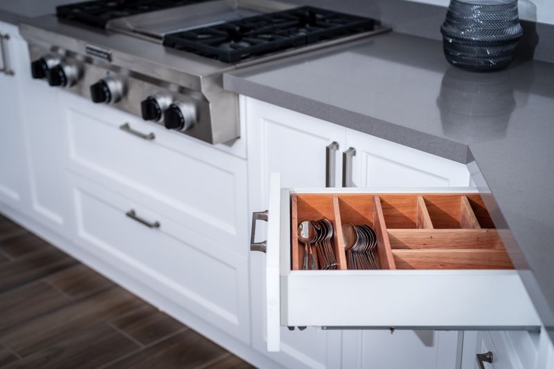 Cajón de cocina organizado junto a una cocina de acero