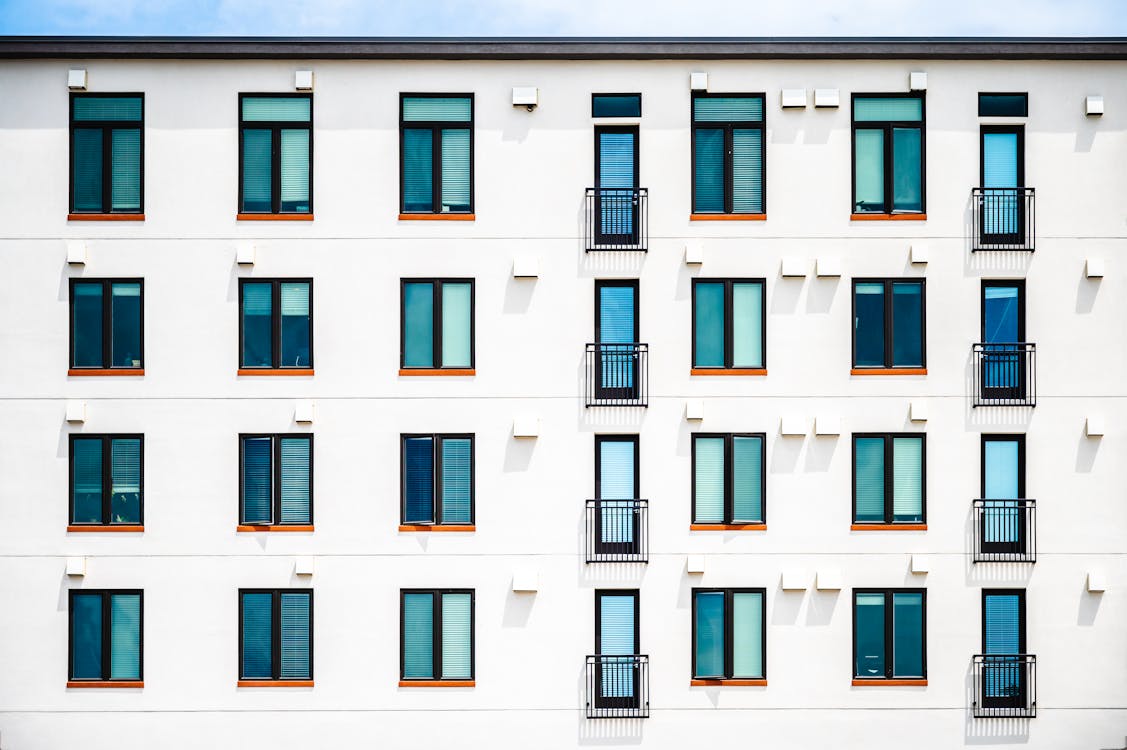 Free Facade Of New White Apartment Building Of Simple Minimalist Style On Clear Day Stock Photo