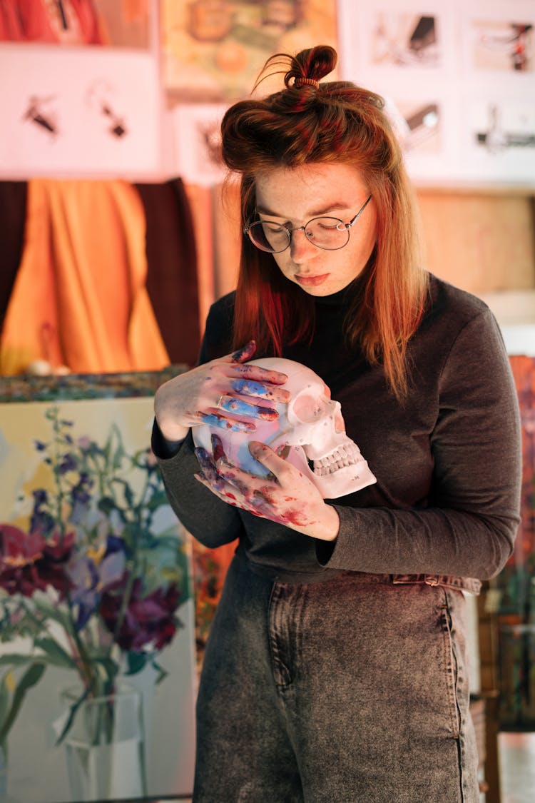 A Woman Holding A Skull Sculpture