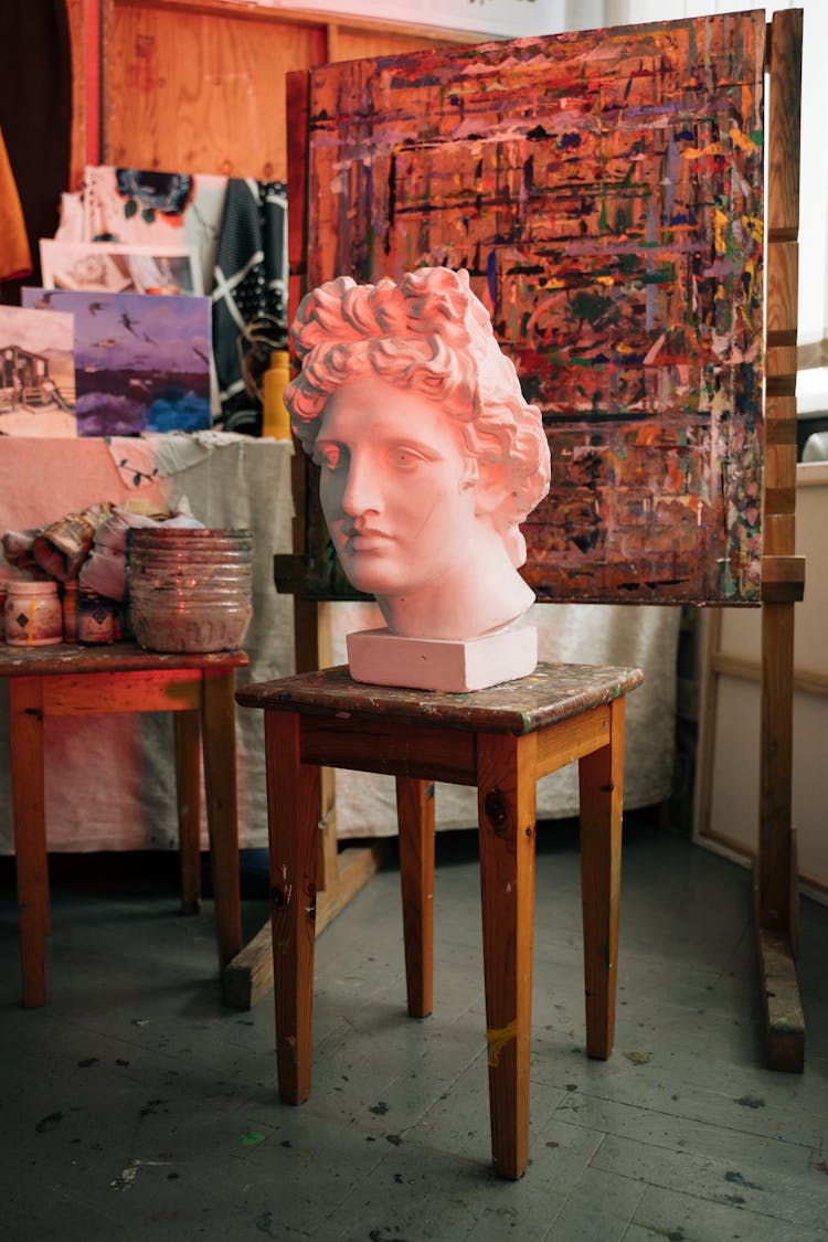 A Sculpture Of David By Michaelangelo On A Brown Wooden Chair