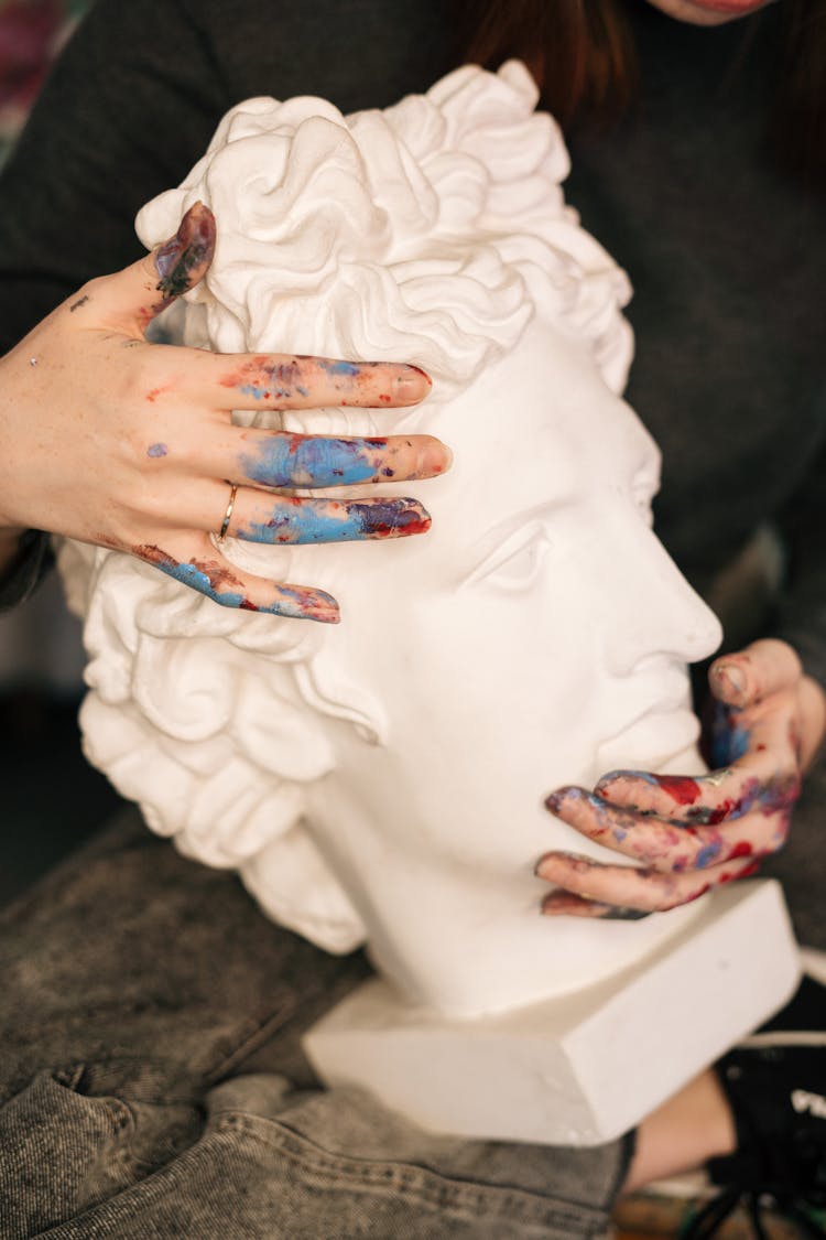 A Person Holding A Sculpture Of David By Michaelangelo