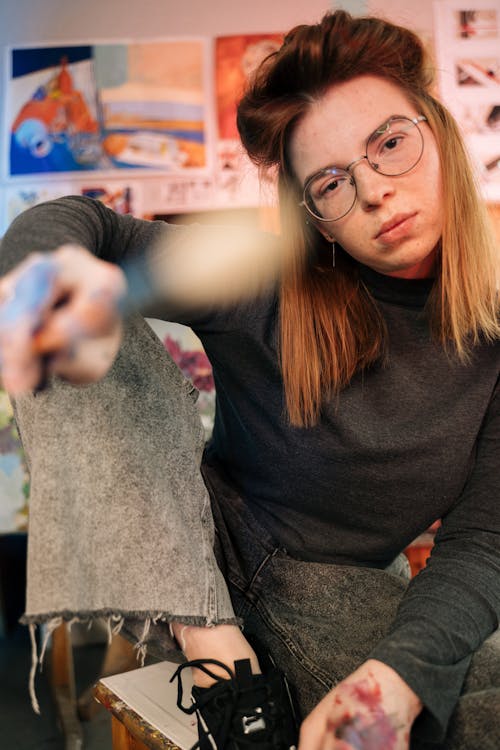 A Beautiful Woman Wearing Eyeglasses Sitting on a Stool