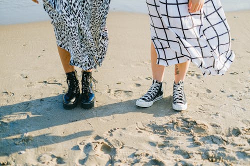 A Couple Wearing Shoes Standing on Shore