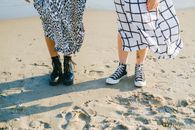 A Couple Wearing Shoes Standing on Shore