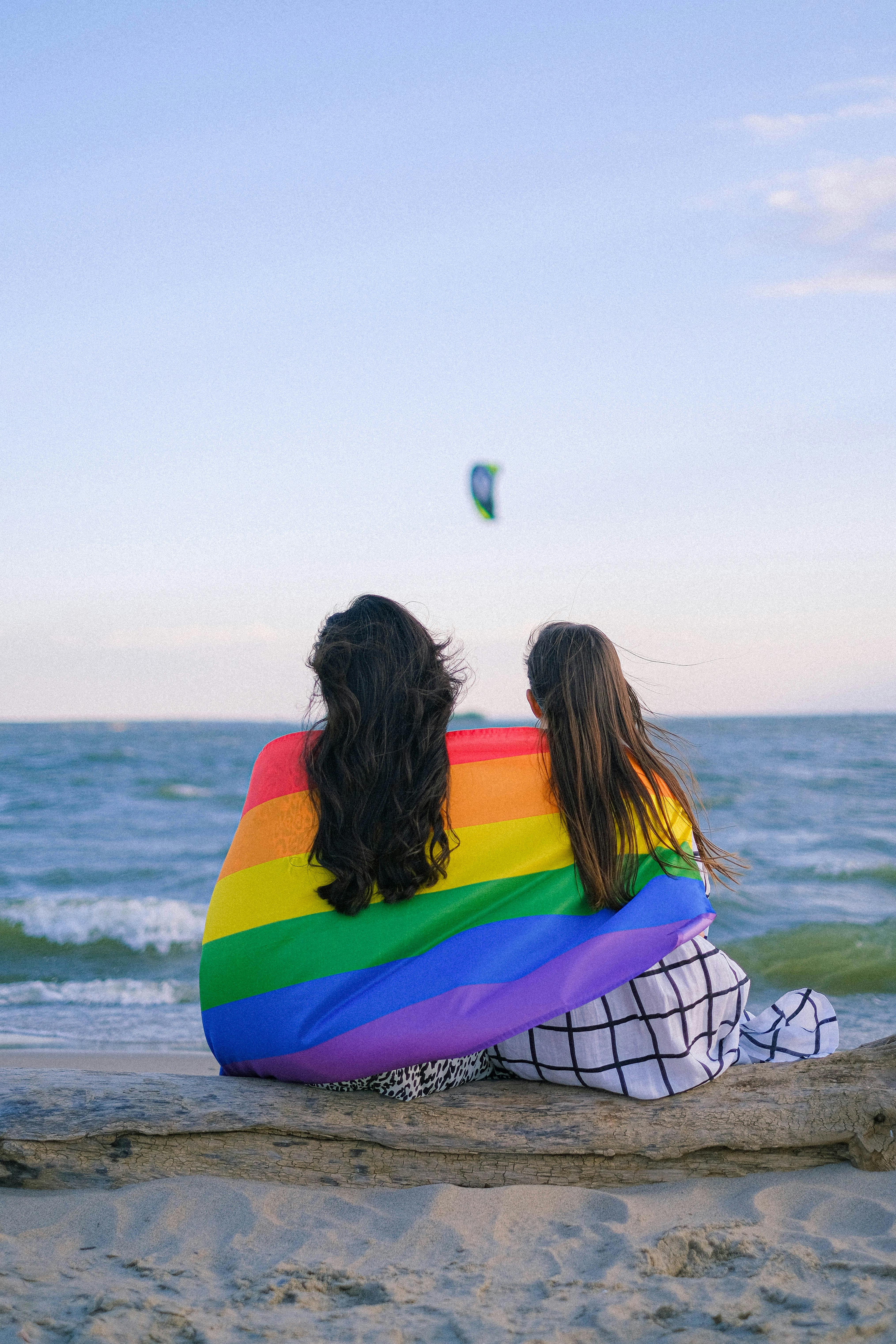 a couple wrapped in rainbow flag