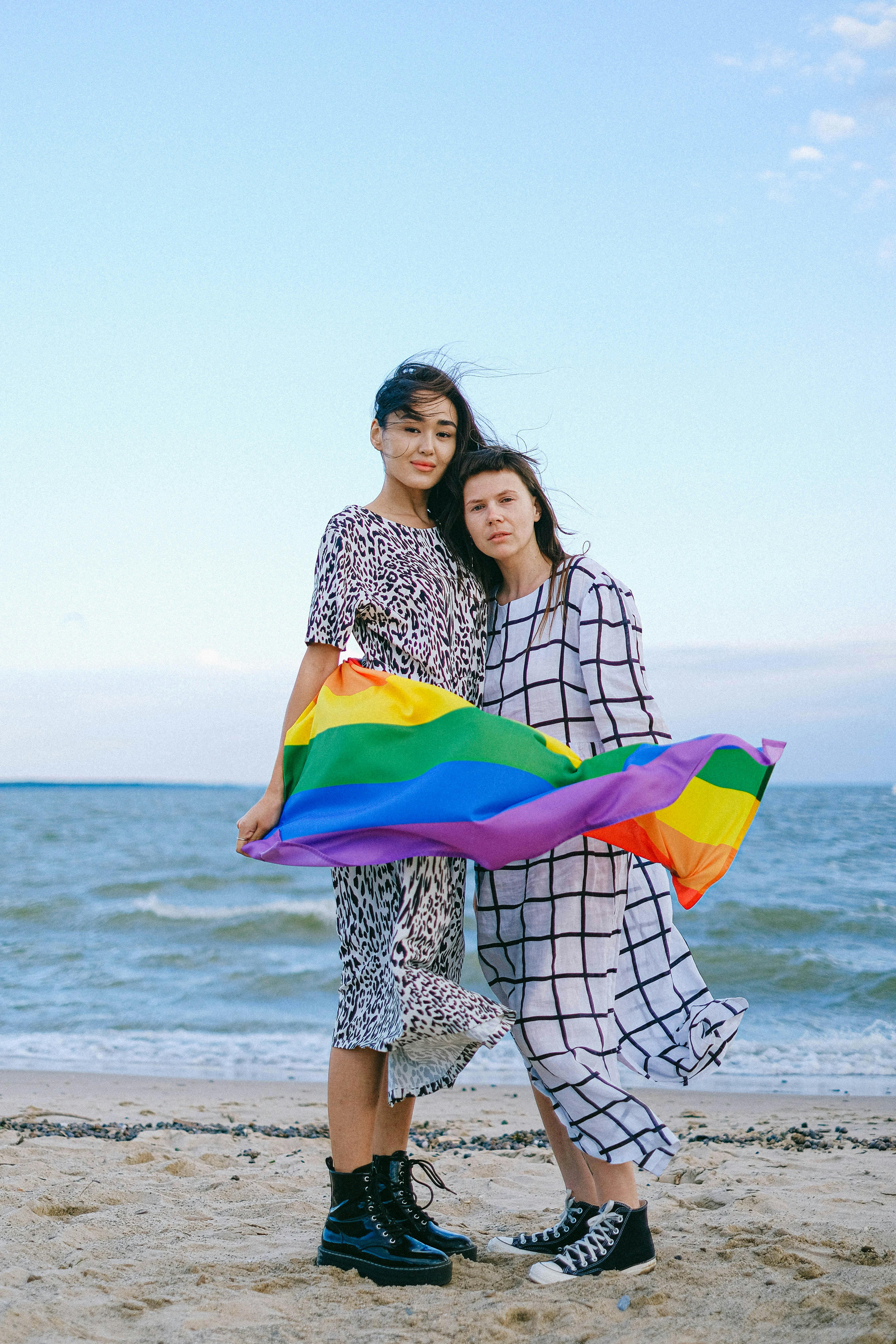 a couple posing with a rainbow flag