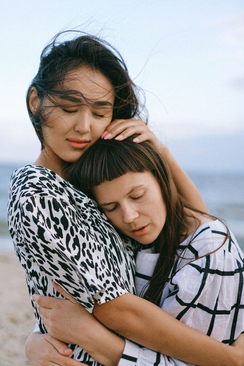 Free An intimate moment of a couple embracing on a beach, capturing love and connection. Stock Photo