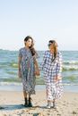 Women standing close on beach in sunny weather