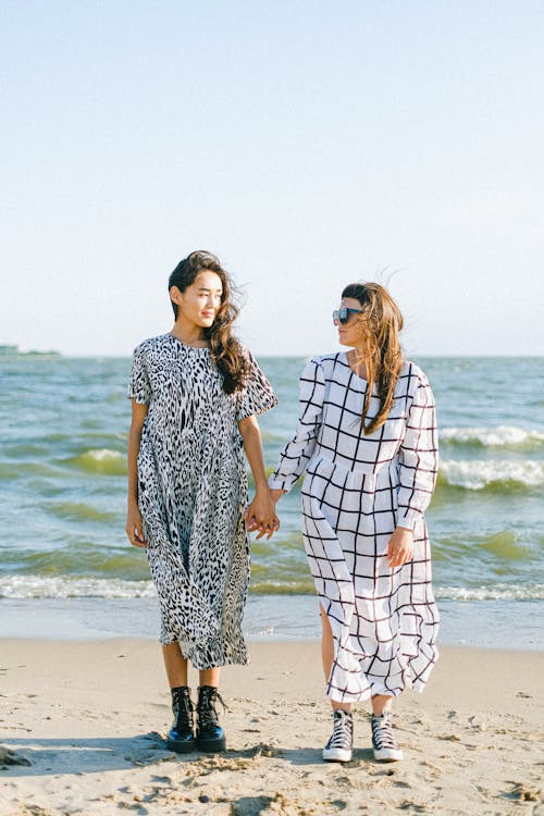 Women standing close on beach in sunny weather