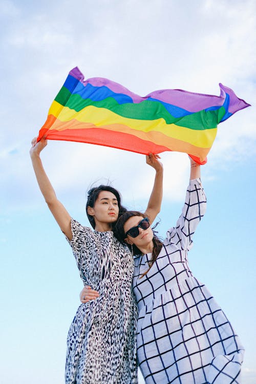 A Couple Waving a Rainbow Flag