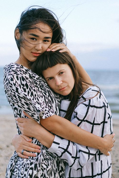 Free A tender moment between two women embracing by the sea. Capturing love and connection. Stock Photo
