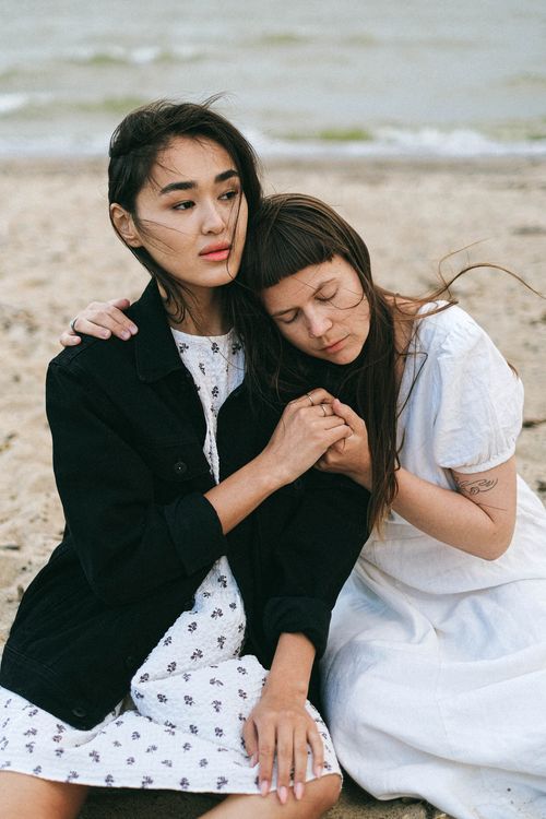 Free An affectionate couple embraces on a sandy beach, symbolizing love and diversity. Stock Photo