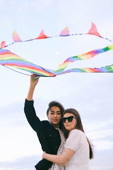 两个女人放飞彩虹风筝时拥抱，象征着爱与自由