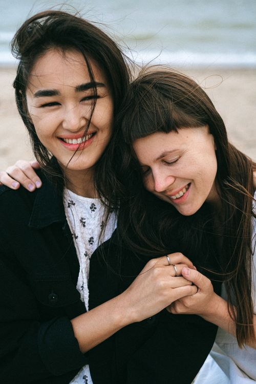 Free A joyful couple smiling and embracing on a beach, depicting love and happiness. Stock Photo