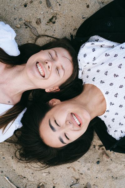 Two teammates laughing together — photo by Anna Shvets on Pexels