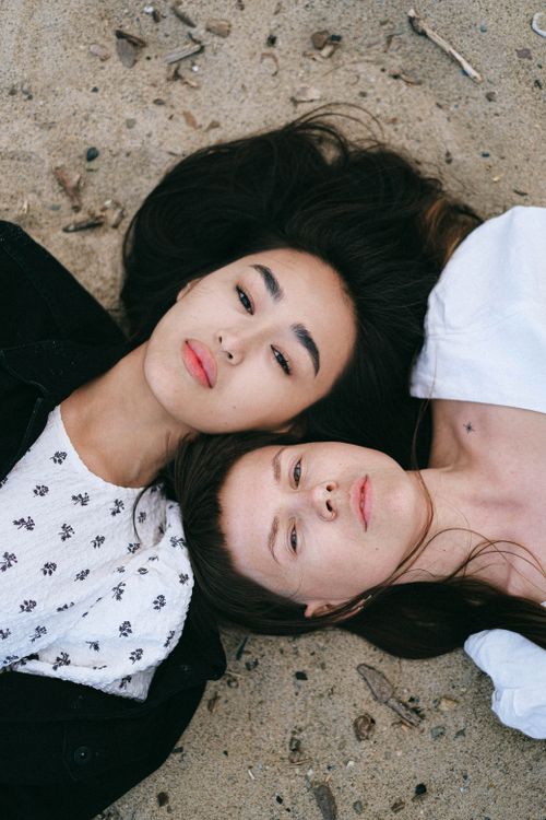 Free A serene portrait of a loving couple lying on the sandy beach, expressing love and togetherness. Stock Photo