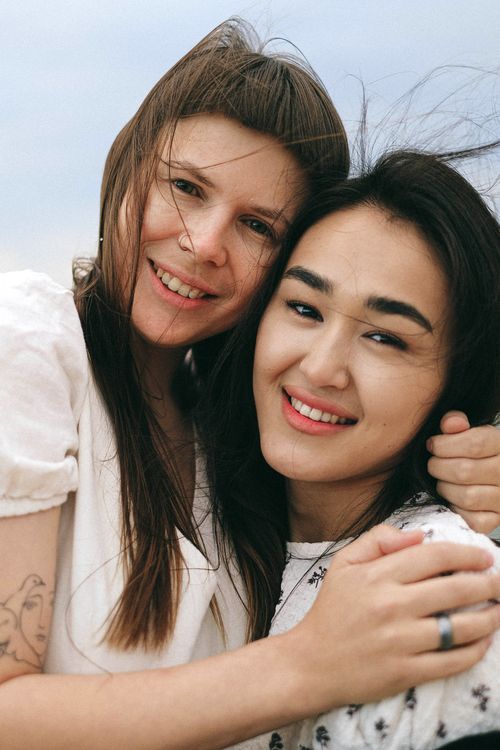 Free A cheerful couple embracing outdoors with smiles, representing love and togetherness. Stock Photo