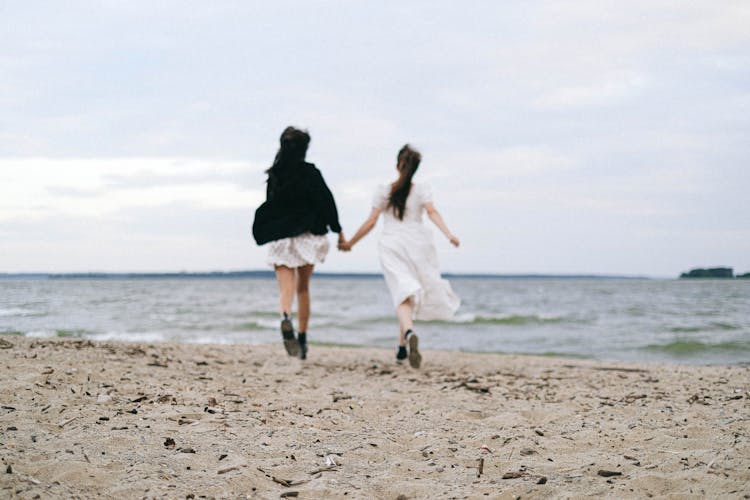 A Couple Running On The Beach