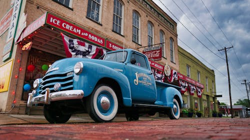 A Blue Vintage Car Parked in front of a Building
