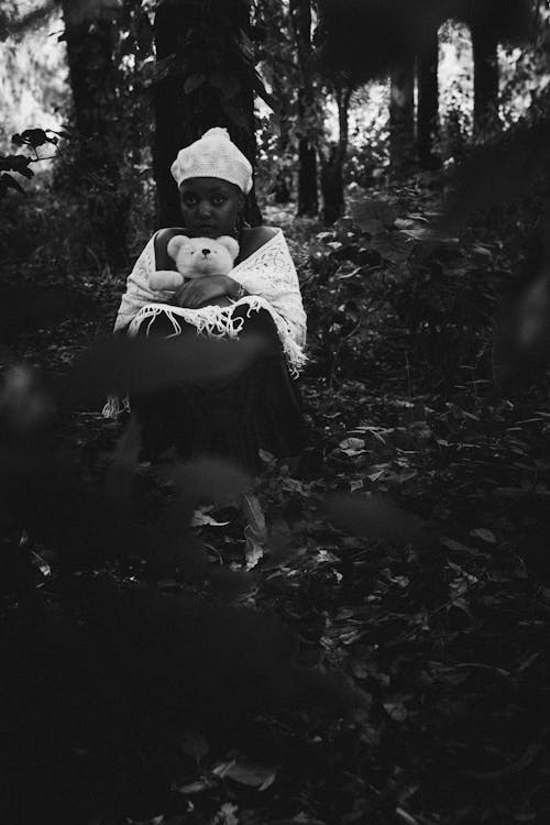 Black and White Photo of Woman Holding a Teddy Bear on Forest 
