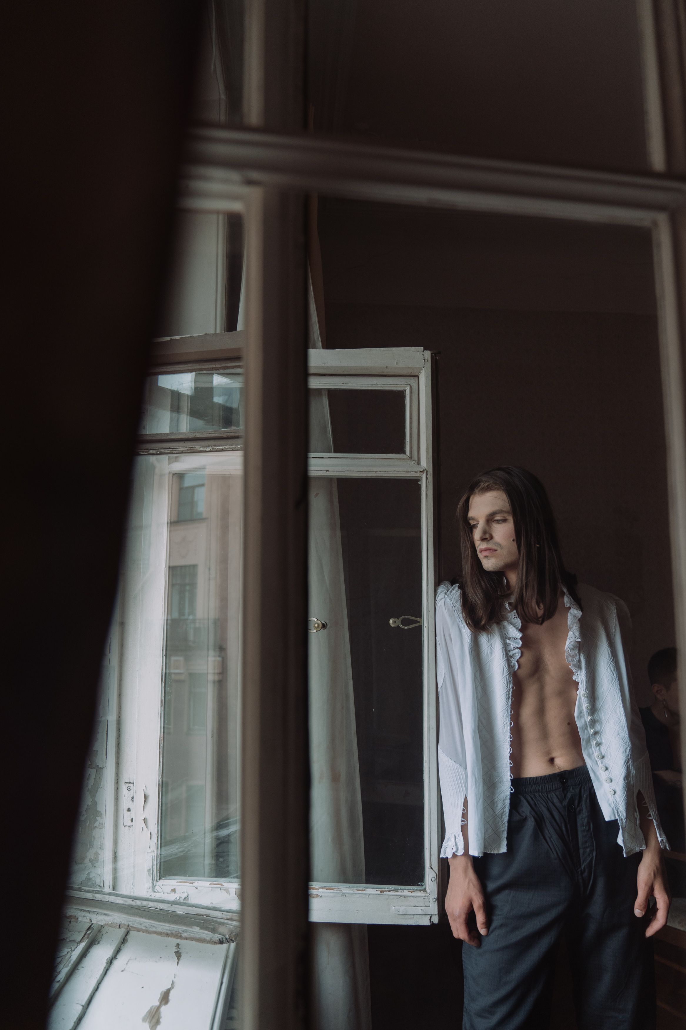 Woman in Blue Shirt Standing Beside Glass Window · Free Stock Photo