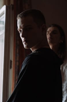 A cinematic and mysterious portrait of two adults indoors, evoking a sense of suspense.