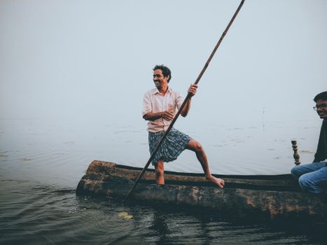 Woman in White Shirt and Blue Skirt Sitting on Brown Wooden Log on Body of Water