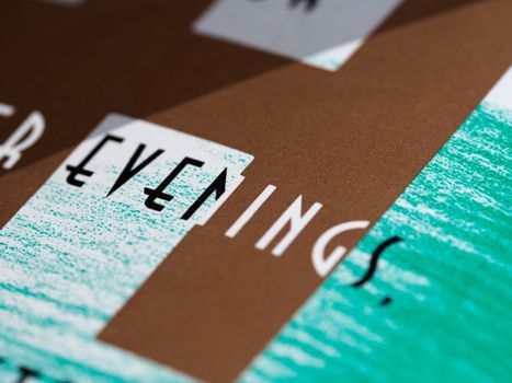 Detailed close-up of typography with 'evenings' on textured paper, highlighting color contrast.