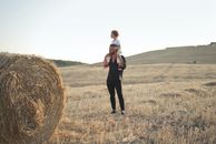 Woman in Black Jacket Standing on Brown Grass Field
