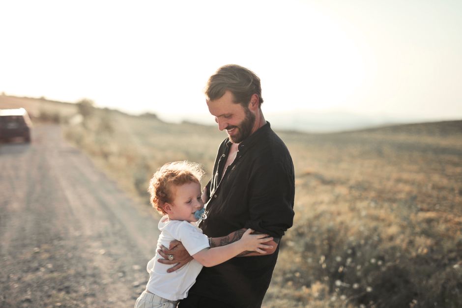 Escena conmovedora de un padre y su hijo abrazándose en un camino rural durante el atardecer.