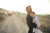 Man in Black Suit Jacket Carrying Boy in White Shirt