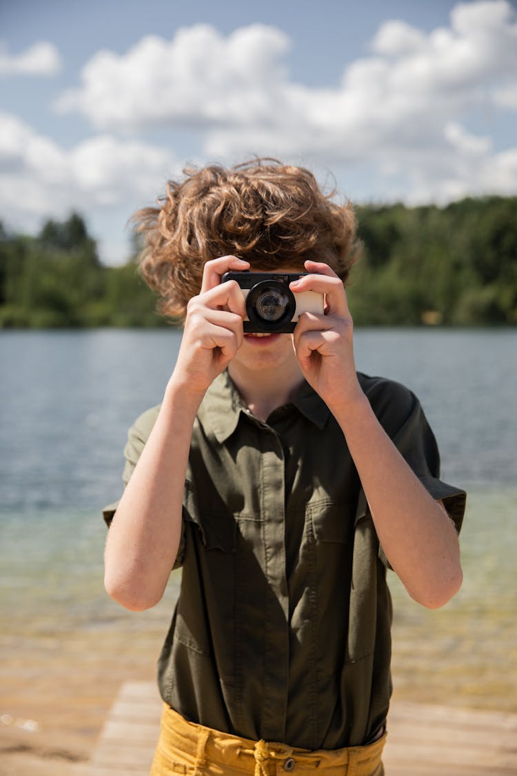 Boy With Camera Near Lake