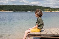 Woman in Gray Long Sleeve Shirt and Yellow Skirt Sitting on Brown Wooden Bench