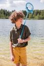 Boy with Fishing Net near Lake