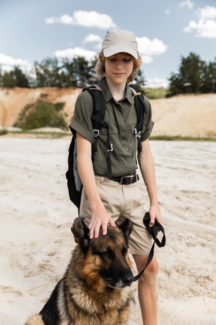 Scout With A Dog Standing On Sand