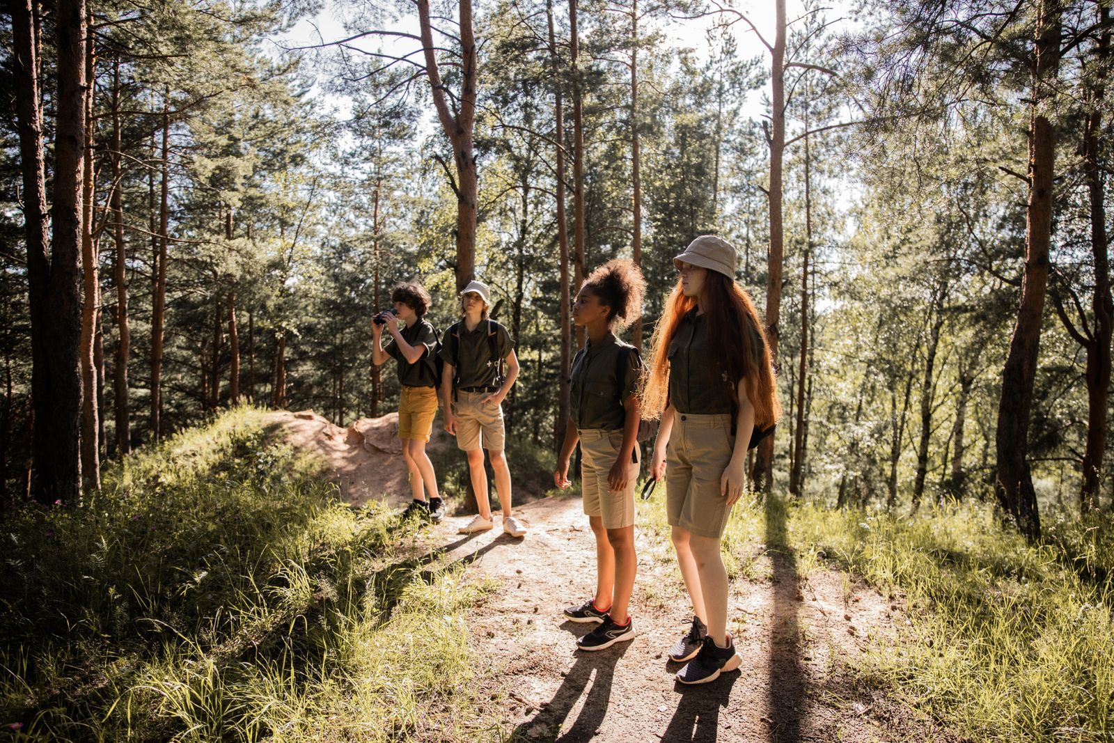 Teens walking a sunlit forest trail