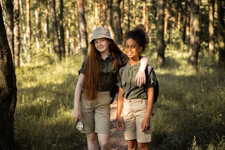 Portrait Of Smiling Girls Scouts In Forest