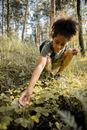 Boy in Black T-shirt and Yellow Shorts Sitting on Ground Surrounded by Green Plants during